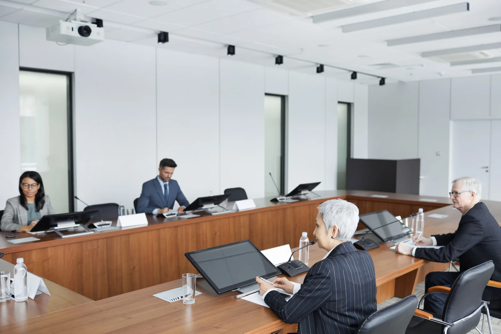 Diverse group of business professionals in a conference room engaged in a meeting.